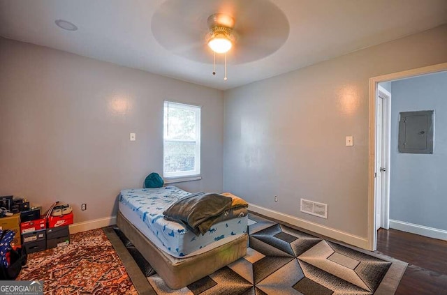 bedroom featuring electric panel, ceiling fan, and dark wood-type flooring