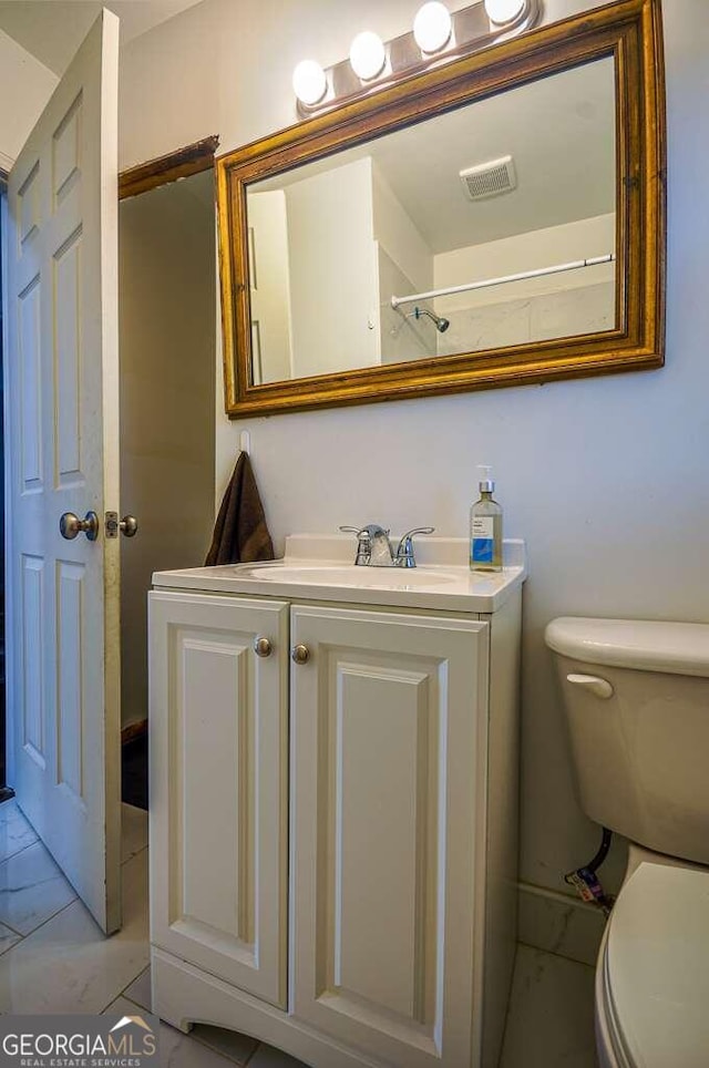 bathroom featuring toilet and vanity