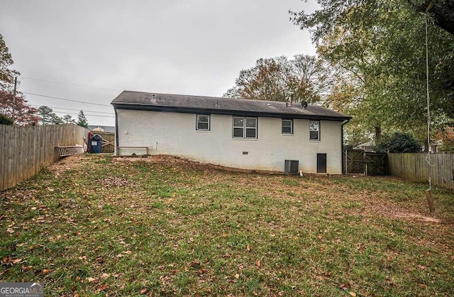 back of property with a lawn and cooling unit