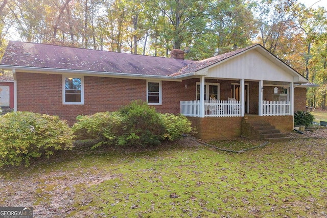 ranch-style house featuring a front lawn and covered porch