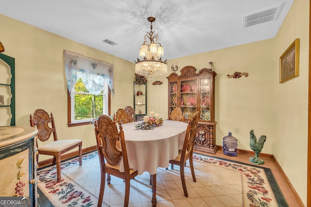 dining area featuring a chandelier and light tile patterned flooring