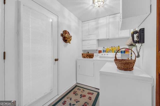 washroom featuring cabinets and washing machine and clothes dryer