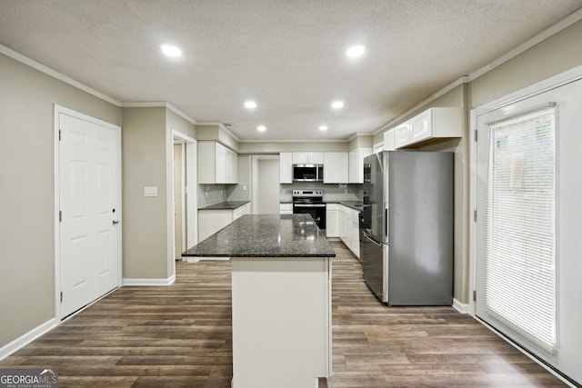 kitchen featuring dark hardwood / wood-style flooring, a kitchen island, white cabinetry, appliances with stainless steel finishes, and dark stone countertops