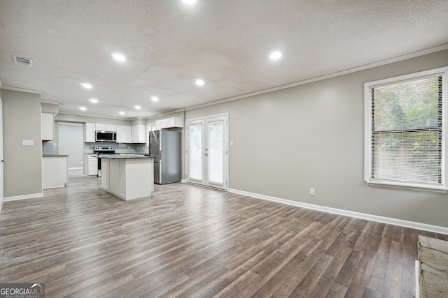 kitchen featuring plenty of natural light, white cabinets, hardwood / wood-style floors, and stainless steel appliances