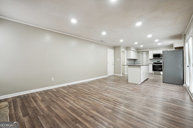 kitchen with white cabinets, crown molding, light wood-type flooring, and appliances with stainless steel finishes