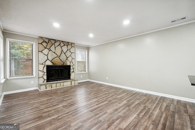 unfurnished living room with a fireplace, wood-type flooring, and crown molding