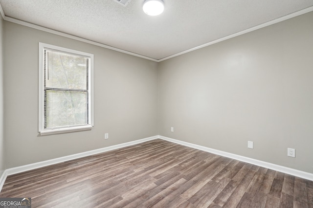 spare room featuring a textured ceiling, hardwood / wood-style flooring, and ornamental molding