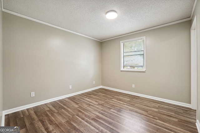 empty room with hardwood / wood-style flooring, a textured ceiling, and ornamental molding