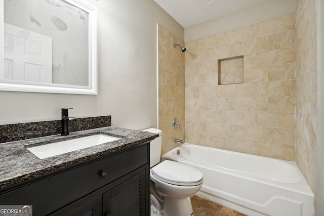 full bathroom with a textured ceiling, vanity, tile patterned floors, toilet, and tiled shower / bath combo