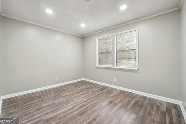 spare room with wood-type flooring, ornamental molding, and a textured ceiling