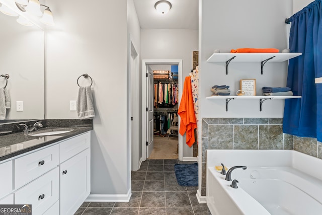 bathroom featuring vanity, tile patterned floors, and a washtub