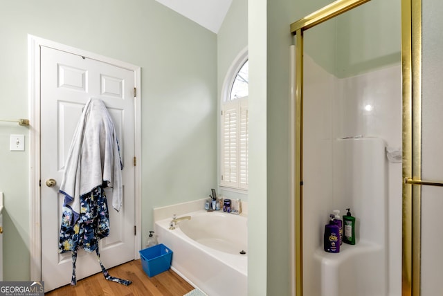 bathroom featuring plus walk in shower, wood-type flooring, and vaulted ceiling