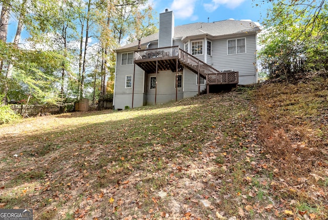 rear view of property featuring a wooden deck and a yard