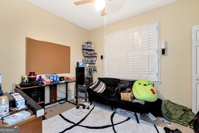 carpeted office space featuring ceiling fan