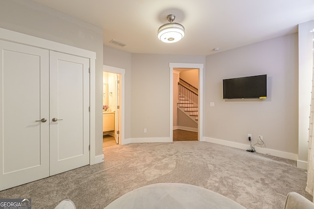 carpeted bedroom with a closet and ensuite bathroom