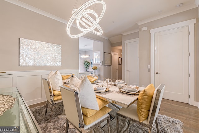 dining area featuring a chandelier, ornamental molding, and wood-type flooring