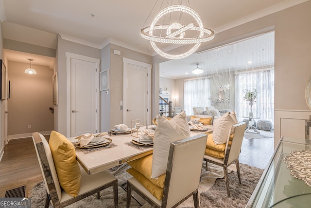 dining room with a chandelier, hardwood / wood-style flooring, and ornamental molding