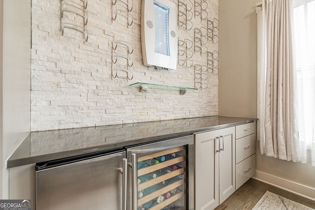 bar featuring dark hardwood / wood-style flooring, beverage cooler, and white cabinets