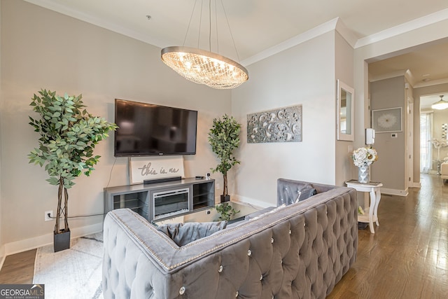 living room featuring hardwood / wood-style flooring, an inviting chandelier, and crown molding