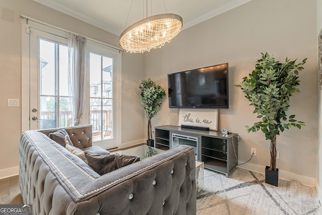 living room featuring light hardwood / wood-style flooring, crown molding, and an inviting chandelier