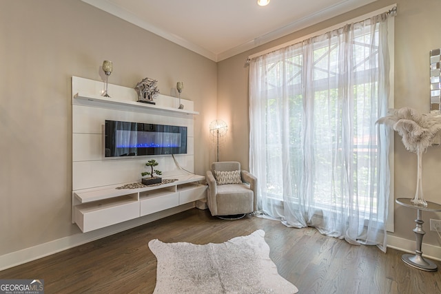 sitting room with dark hardwood / wood-style flooring and crown molding