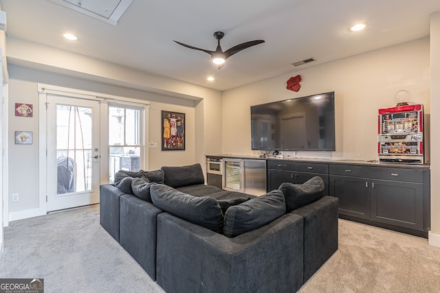 living room featuring ceiling fan, beverage cooler, light carpet, and french doors