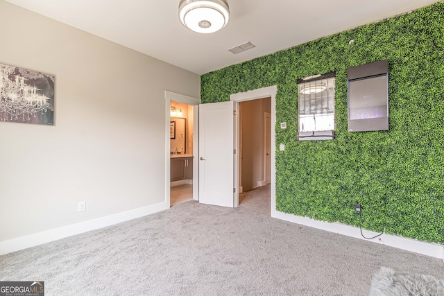 unfurnished bedroom featuring carpet flooring and ensuite bath