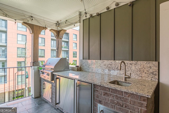 view of patio featuring a balcony, area for grilling, sink, and exterior kitchen