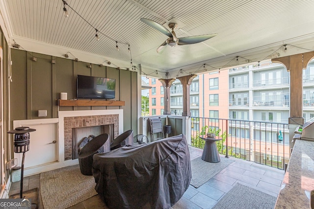 sunroom with a fireplace and ceiling fan