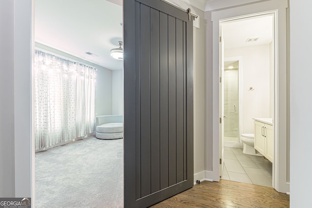 bathroom featuring vanity, hardwood / wood-style flooring, toilet, and a shower with shower door