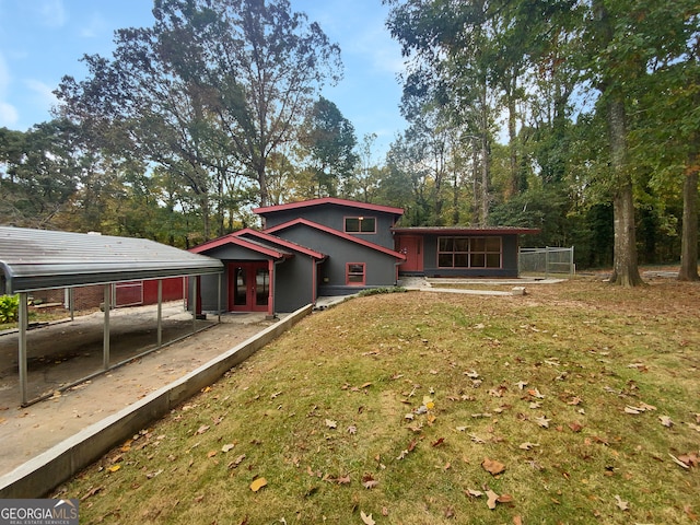 rear view of house with a lawn and a carport