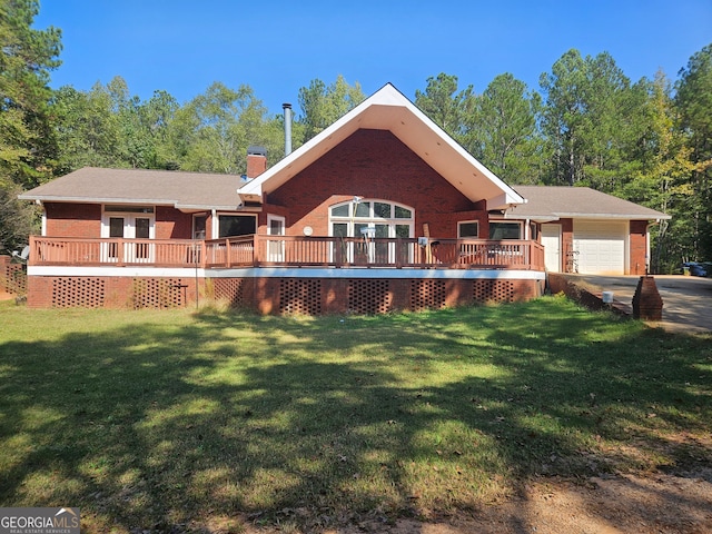 view of front of property with a front yard, a wooden deck, and a garage