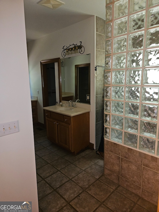 bathroom with walk in shower, tile patterned flooring, and vanity