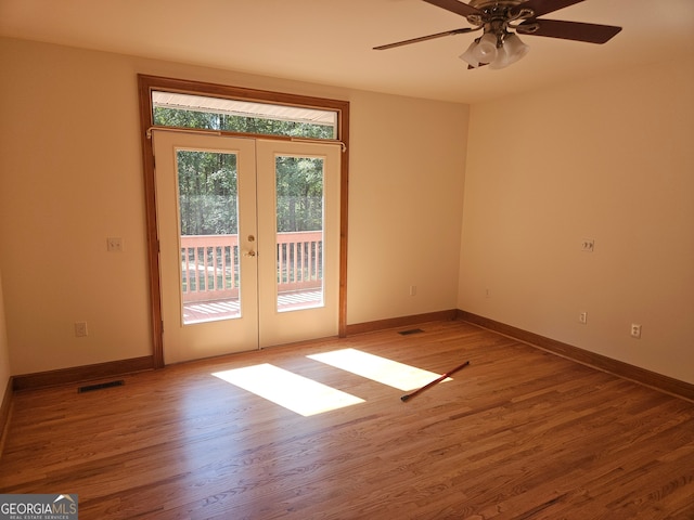 empty room with hardwood / wood-style floors, ceiling fan, and french doors