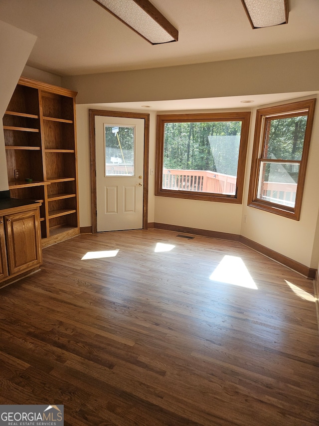 unfurnished living room with dark hardwood / wood-style flooring