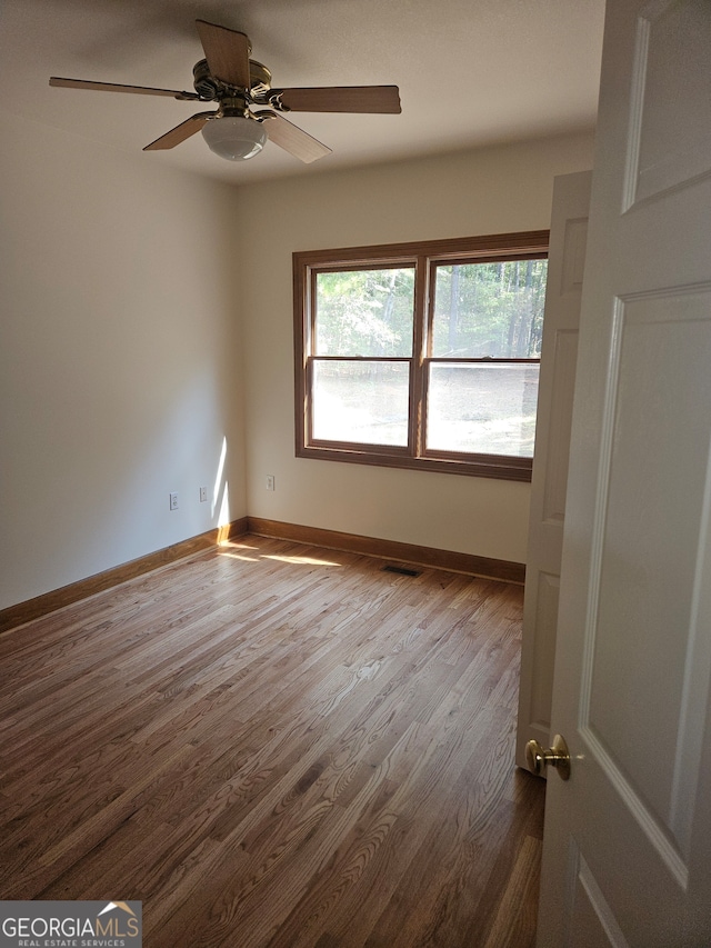 unfurnished room with hardwood / wood-style floors and ceiling fan