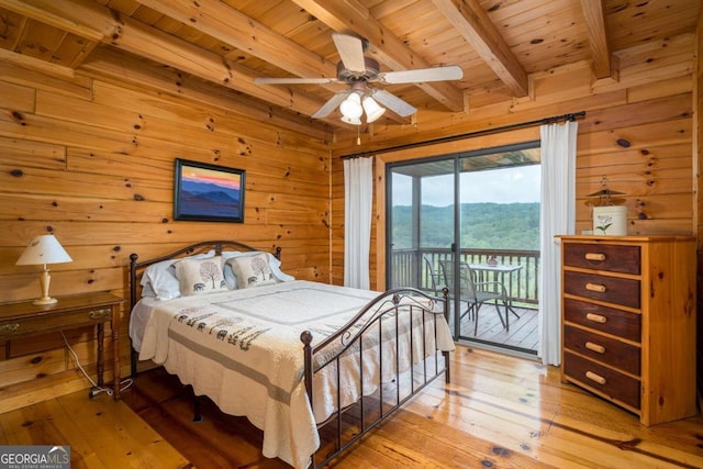 bedroom with wood walls, light hardwood / wood-style floors, beamed ceiling, wooden ceiling, and access to outside