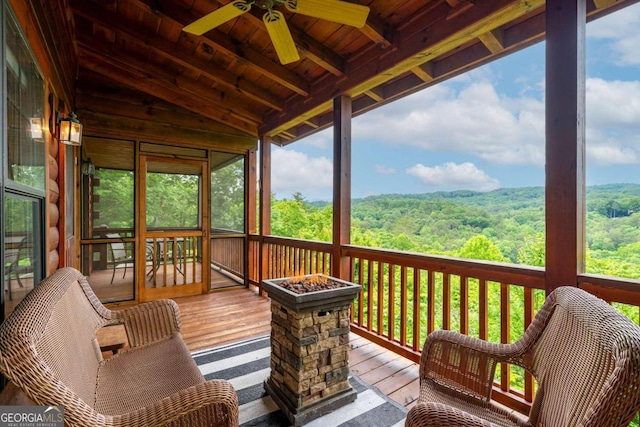 sunroom / solarium featuring a wealth of natural light, ceiling fan, and vaulted ceiling with beams