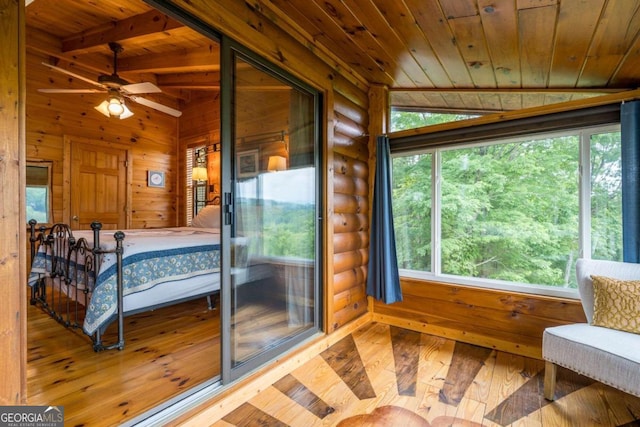 sunroom featuring lofted ceiling, ceiling fan, and wood ceiling