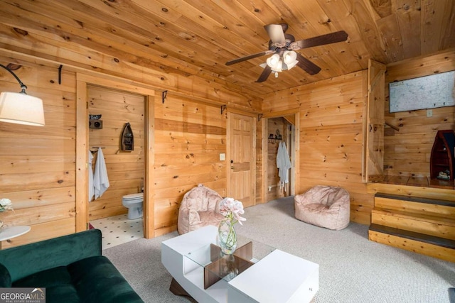 carpeted living room with wood walls, wood ceiling, and ceiling fan