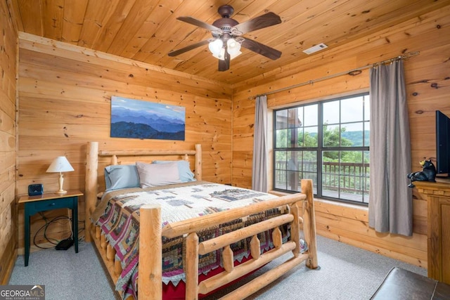 bedroom with light colored carpet, wood walls, ceiling fan, and wooden ceiling