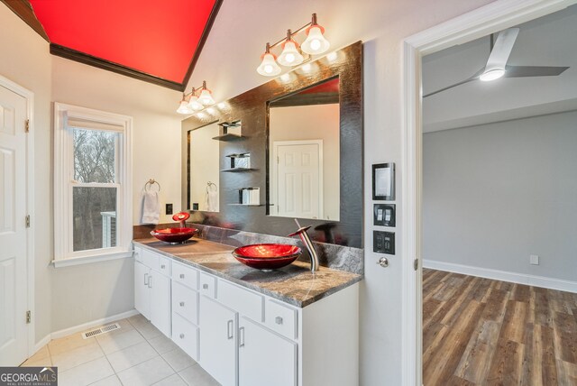 kitchen with light stone countertops, sink, and a towering ceiling