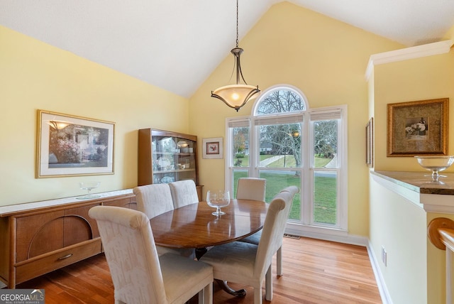 dining area featuring light hardwood / wood-style floors, a healthy amount of sunlight, and high vaulted ceiling