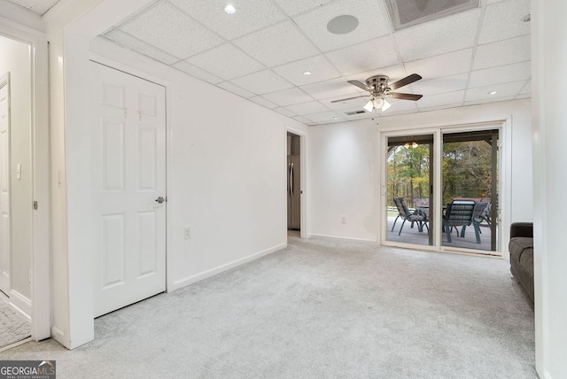 carpeted empty room featuring a drop ceiling and ceiling fan