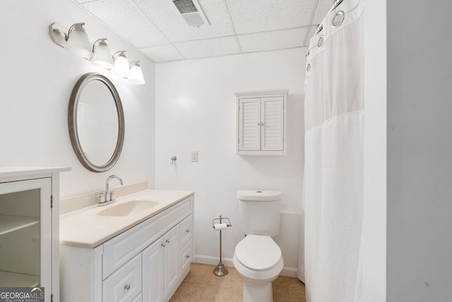 bathroom with tile patterned flooring, a paneled ceiling, vanity, and toilet