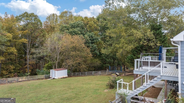 view of yard featuring a storage unit and a deck