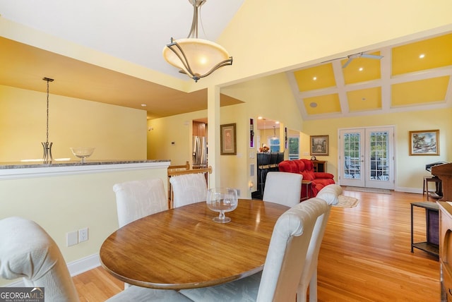 dining room featuring high vaulted ceiling, french doors, ceiling fan, and light hardwood / wood-style flooring