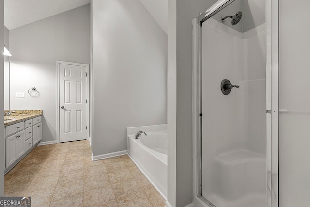 bathroom featuring vanity, vaulted ceiling, and independent shower and bath