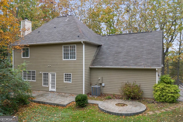 rear view of house with central AC, a patio, and a fire pit