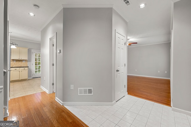 hallway featuring a textured ceiling, crown molding, and light hardwood / wood-style flooring